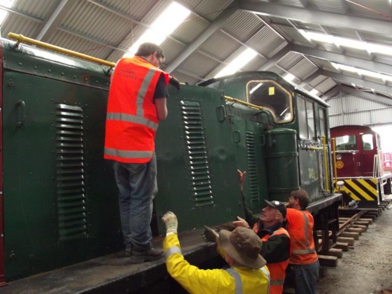 Trust members checking over the locomotive, safely stored inside the rail vehicle shed.