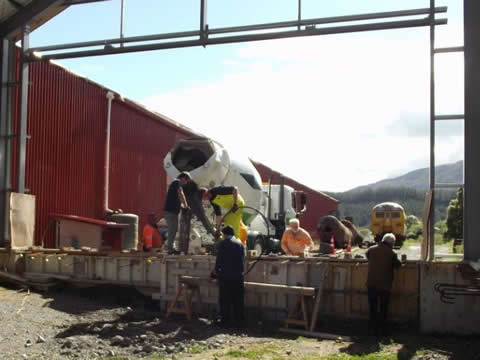 Placing concrete into formwork for foundation end wall