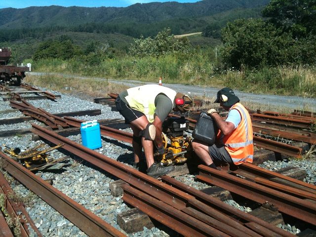 Colin and John drilling closer rails for the double-slip. Four rails were selected, straightened, cut and both heel bolt holes and fishbolt holes drilled. 21 January 2012. Photo: Hugh McCracken.