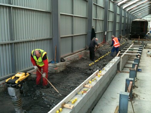 Peter, Steve and John placing back-fill behind pit wall on Saturday 30 June 2012. Formwork was already in place for a second pit wall pour.