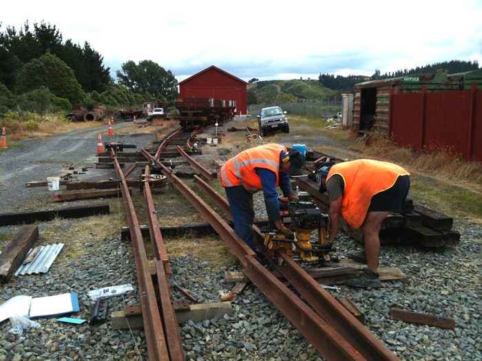 John and Colin drilling heel bolt holes in the straight stock rail, whilst the curved closer rail is being crowed to required radius.