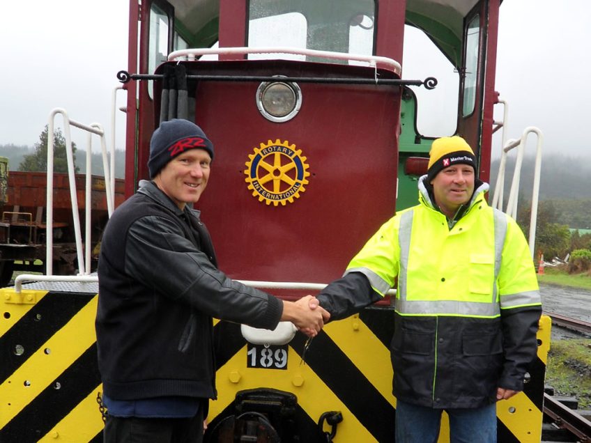 Kevin Joyce, right, and Hugh McCracken, left, celebrate unveiling of Rotary International badge affixed to shunting locomotive Tr 189
