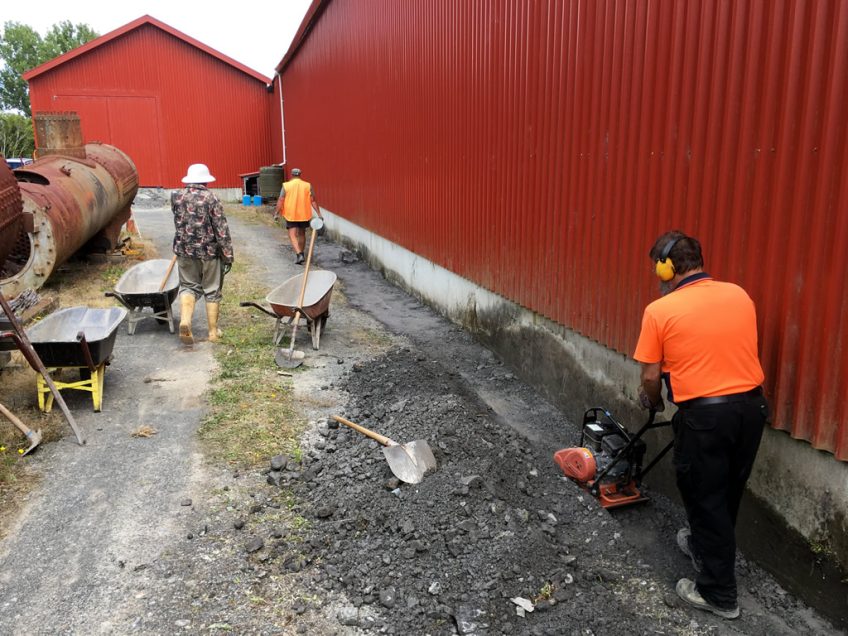 Compacting fill along the south side of the shed 