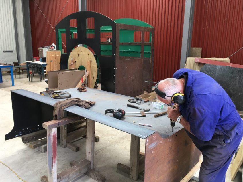 Peter Milburn drilling holes to fasten bunker back to sides