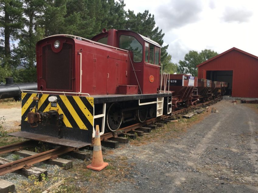 Tr189 shunts Wb 299 frame into the workshop, a rake of ballast wagons used as runners.