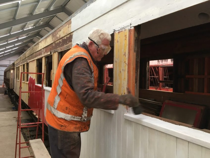 Ron Jones dusting off a window sill for painting