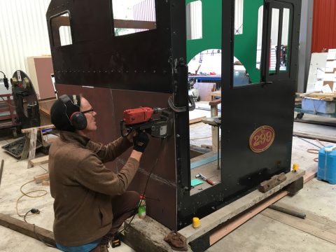 Hugh McCracken driling bolt holes to attach bunker front to cab